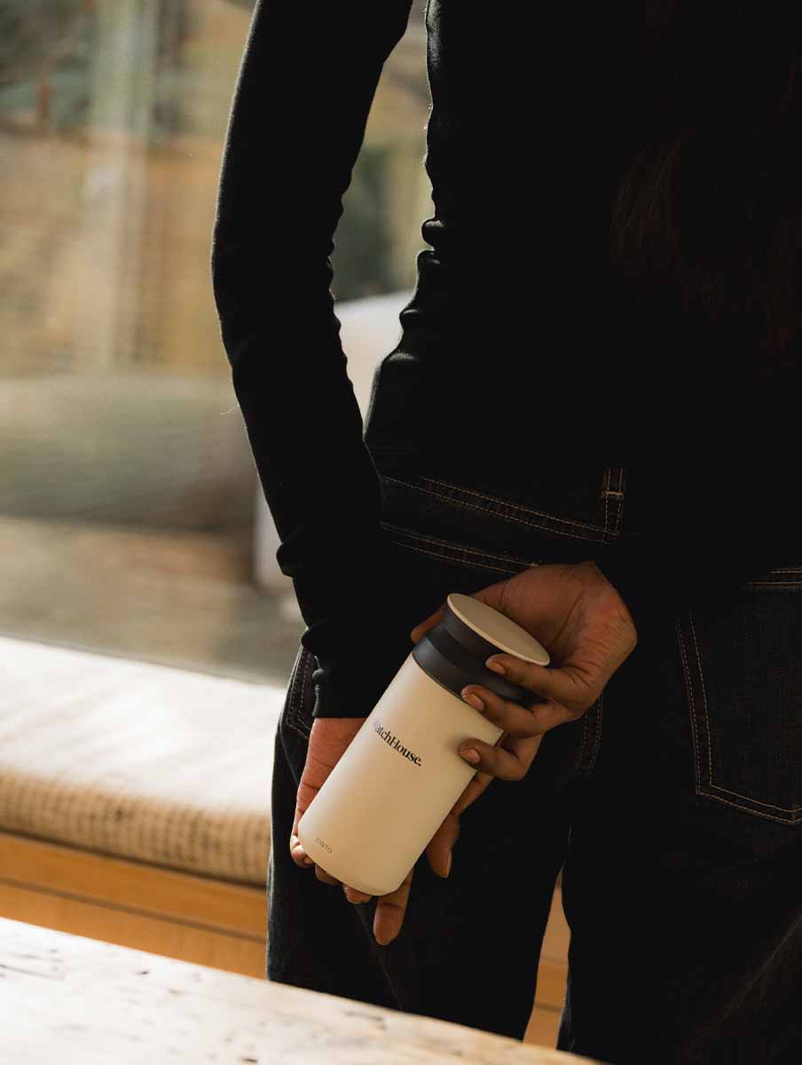 Person holding a kinto tumbler behind their back